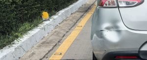 Backside of car has dented rear bumper damaged after accident on the road